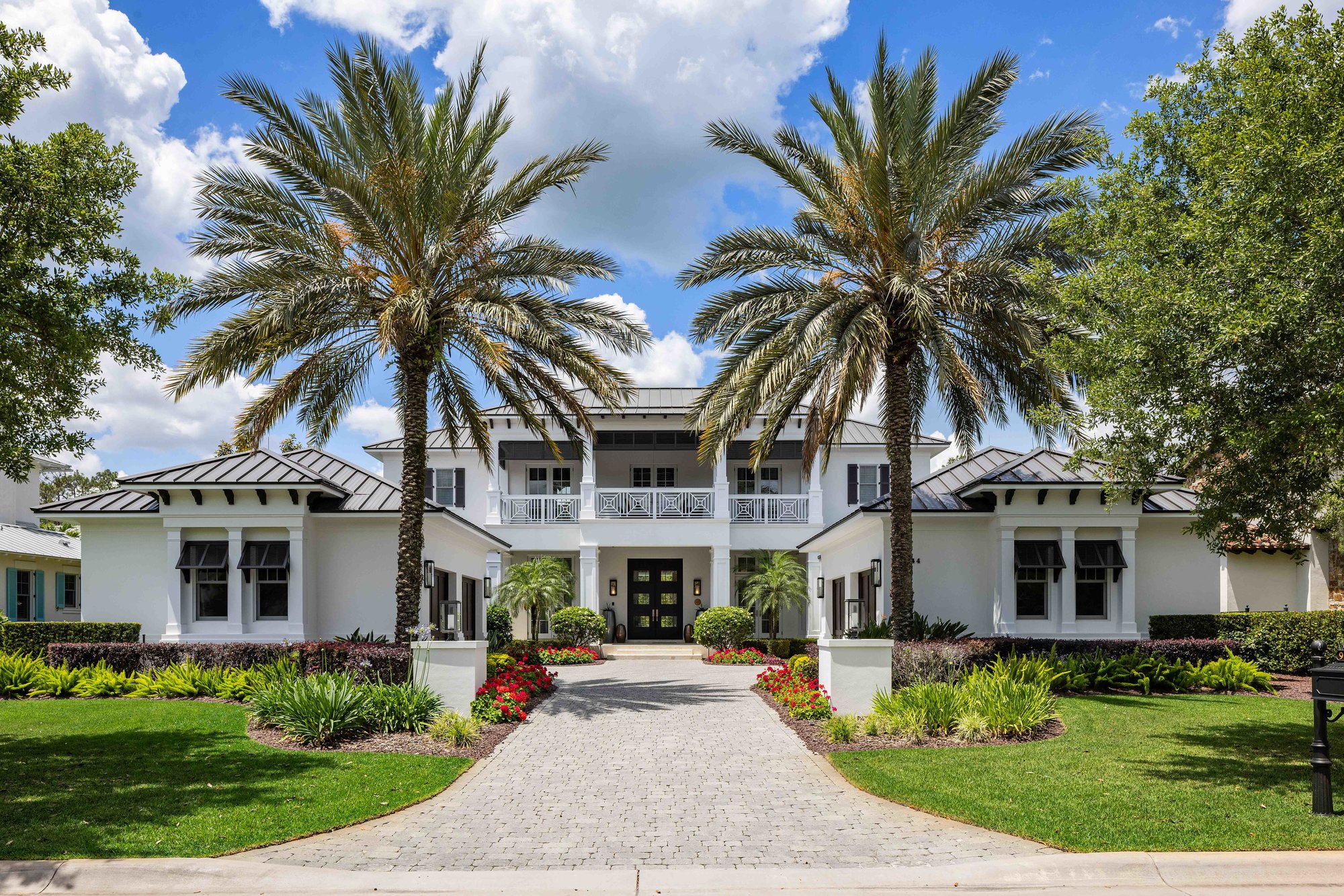 front of two story golden oak home with palm trees